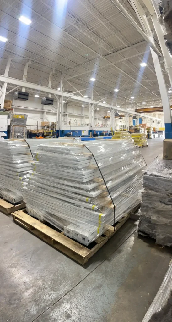 Pallets stacked with panels and gates wrapped in plastic wrap