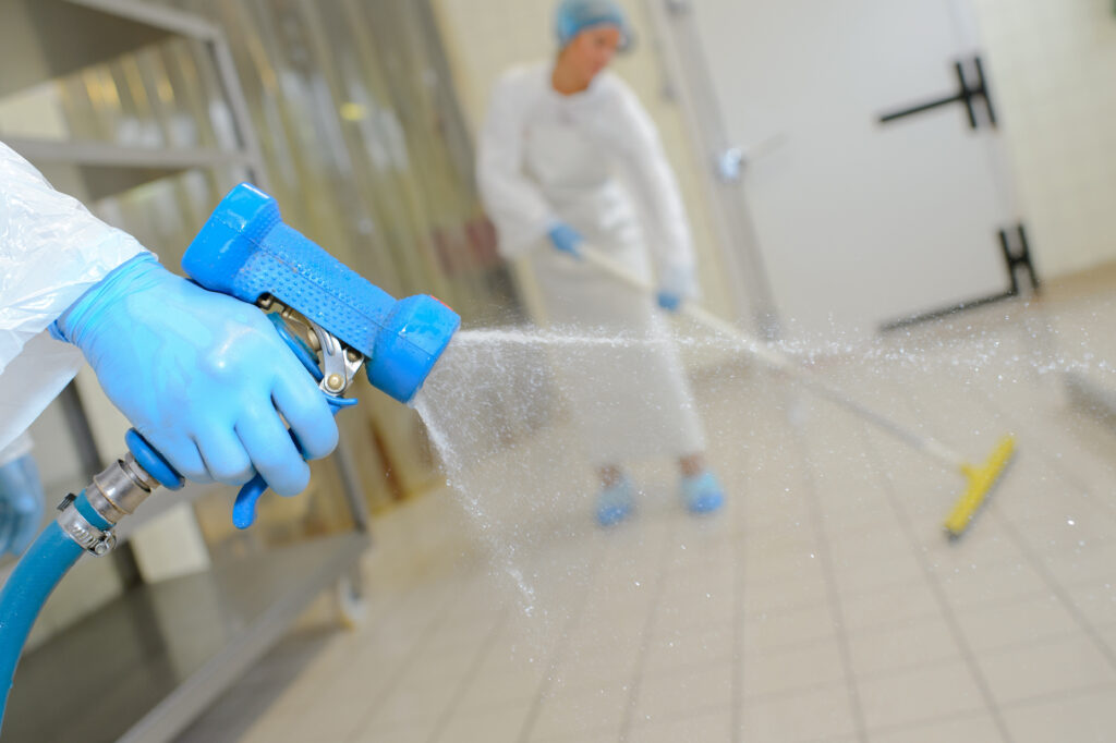 a lab worker sprays down a factory